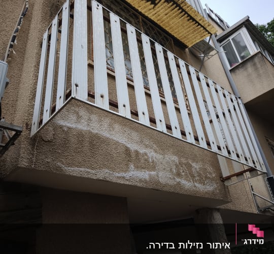 מרפסת עם מעקה מתכת חלוד על בניין מגורים